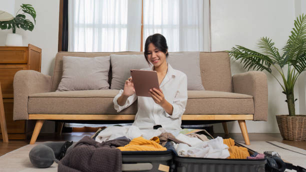 istock Young woman happy after using tablet book a hotel success while preparing travel suitcase 1714737880