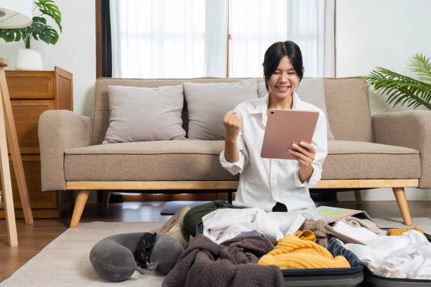istock Young woman happy after using tablet book a hotel success while preparing travel suitcase 1714737885