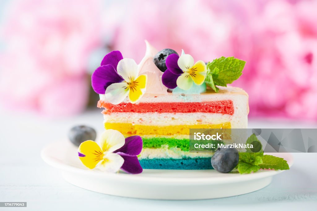 Delicious rainbow cake on plate on table on blue wooden background Cake Stock Photo