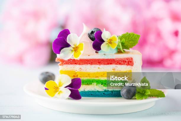 Delicious Rainbow Cake On Plate On Table On Blue Wooden Background Stock Photo - Download Image Now