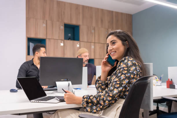 istock Happy woman talking to the mobile while working 1714786494