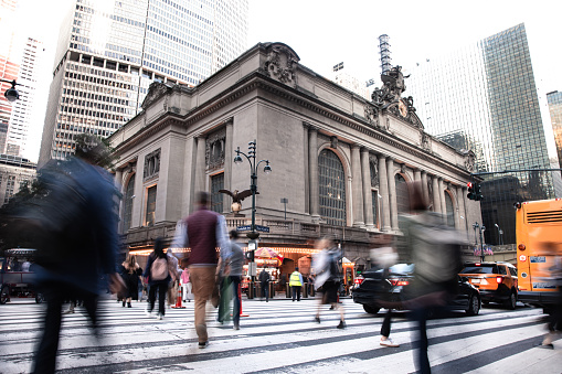 At afternoon rush hour crowded streets in Midtown Manhattan, Grand Central Station on the background.