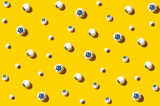istock Halloween background, eyes on yellow table. 1714798184