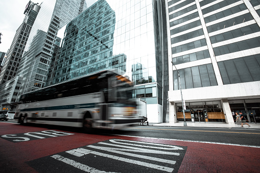 Blurred shot of city streets in Manhattan, New York with blurred people, cars and traffic on the street.