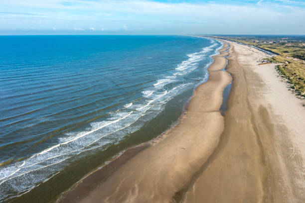 Drone point  of view of Waves, sea and empty beach , static shot. The Netherlands.