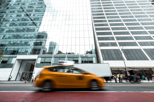 Blurred shot of city streets in Manhattan, New York with blurred people, cars and traffic on the street.