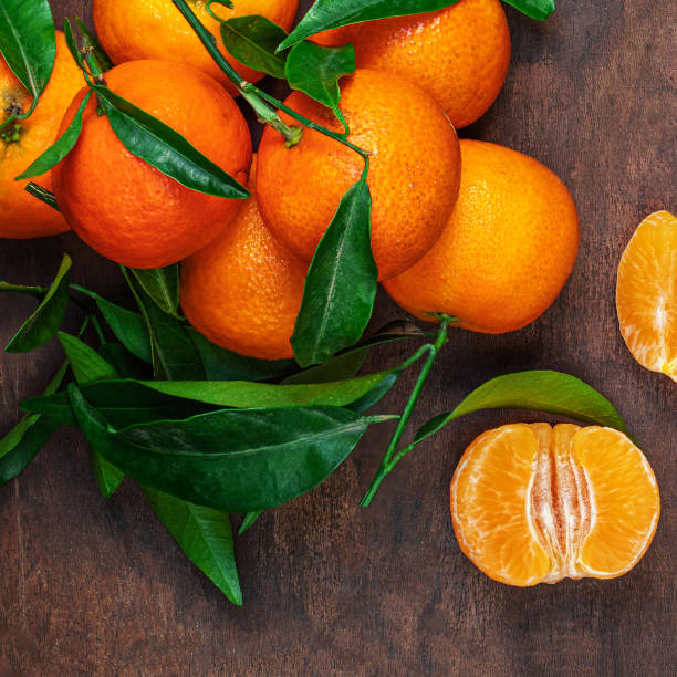 istock Fresh mandarin oranges fruit or tangerines with leaves on rustic wooden table, top view. Flat lay 1714810133