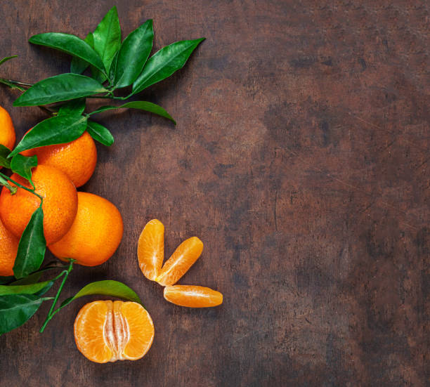 istock Fresh mandarin oranges fruit or tangerines with leaves on rustic wooden table, top view. Flat lay. Copyspace 1714810136