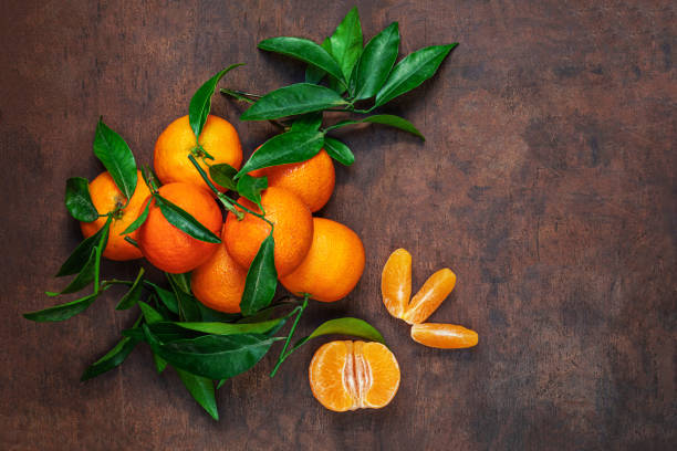 istock Fresh mandarin oranges fruit or tangerines with leaves on rustic wooden table, top view. Flat lay. Copyspace 1714810643