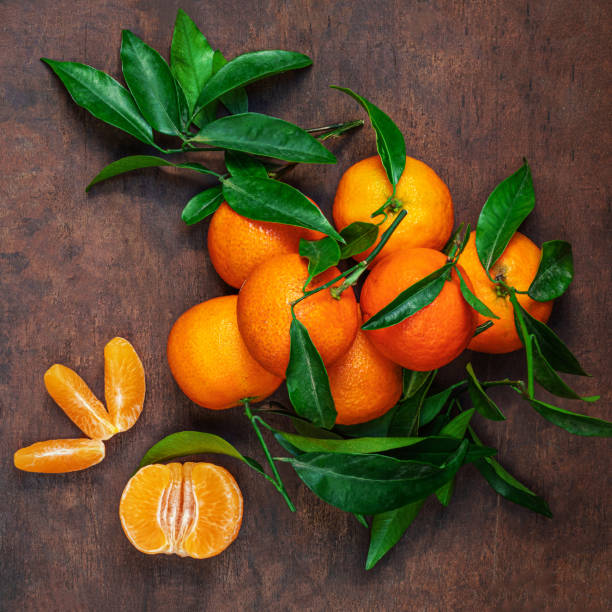 istock Fresh mandarin oranges fruit or tangerines with leaves on rustic wooden table, top view. Flat lay 1714810649