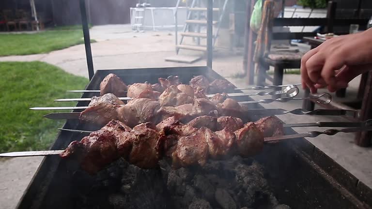 Man barbecuing meat on skewers, close-up, barbecue, barbecue, eating out