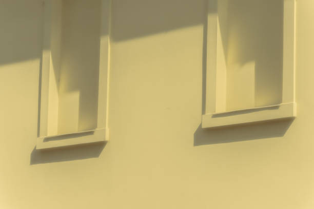 Abstract Geometry: Yellow Wall with Enclosed Windows and Shadows