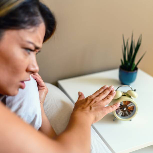 istock Woman shutting off alarm clock 1714823432
