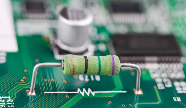 istock Closeup of power carbon resistor and white electronic symbol on green PCB surface 1714845094