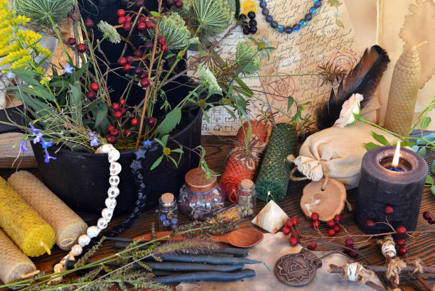 istock Witch pot with herbs for potion, candles and magic objects on altar table. Occult, esoteric and divination still life. Mystic Halloween background with vintage objects for ritual 1714852248