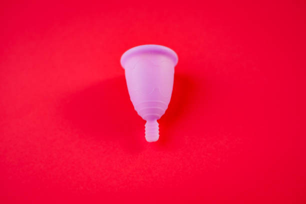 istock A silicone menstrual cup isolated on red background. 1714871170