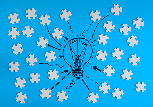 Business concept,collaboration,cooperation,teamwork, innovation,human resources,recruitment,team building with jigsaw puzzle pieces and lightbulb