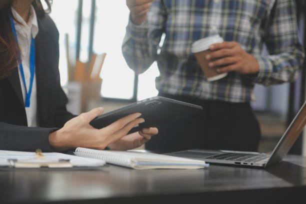 istock Financial analysts analyze business financial reports on a digital tablet planning investment project during a discussion at a meeting of corporate showing the results of their successful teamwork. 1714878660