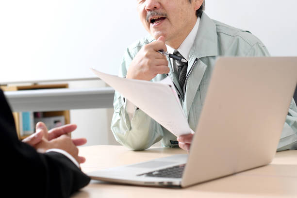 istock A businessman in a suit explaining on a laptop and a middle-aged man in work clothes listening to the explanation. 1714882017