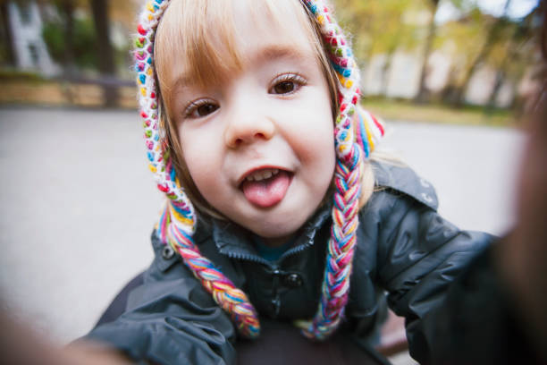 Little cute thoughtful girl in a sundress and a straw hat close-up in the summer outdoors. Concept of children's health, education, active recreation