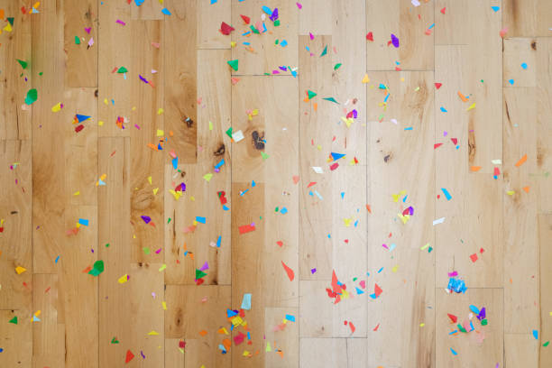 Confetti covers the wooden floor after a celebration, background for design.