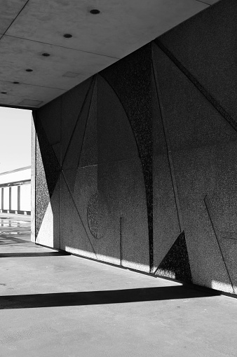 A black and white photograph of a wall featuring an abstract design