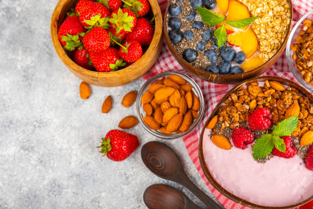 istock Useful breakfast. Granola bowl with yogurt and fresh berries on a textured kitchen table.Acai and spirulina bowl.Bowl of Greek yogurt with granola, almonds, blueberries, raspberries and strawberries 1714902826