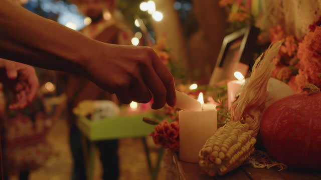 Female Hand Lighting Altar Candles on Day of the Dead