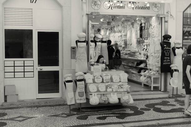 Lisbon, Portugal - July 2, 2022: A seamstress works outside a shop at the Rua Augusta street in Lisbon downtown.
