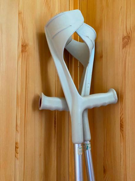 istock Crutches for people with reduced mobility. Crutches with white armrests for people with disabilities rest against a wooden wall 1714924577