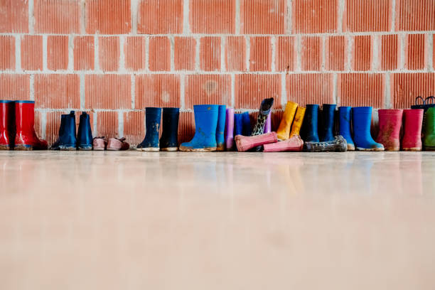 Many muddy colored wellies on the ground.