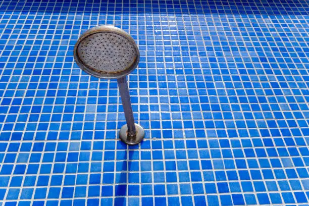 Outdoor shower head in a pool, to cool off in summer.