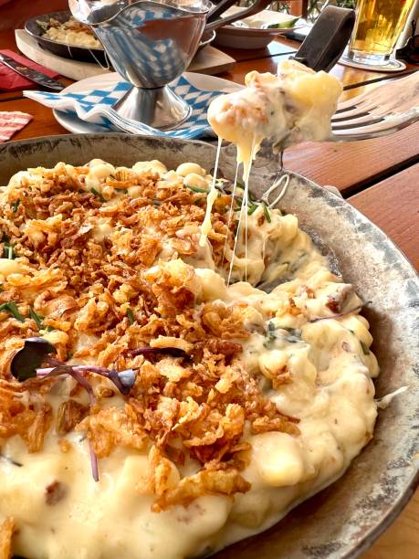istock eating cheese spaetzle with fried onions at Bavarian restaurant with molten cheese 1714938529