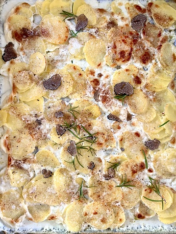 potato au gratin with cheese and cream and black truffle shavings