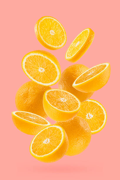 istock Bright oranges closeup levitation as flow, art composition. Whole, half, round slices fruits on pastel pink background, shadow. Summer fruits for advertising, design, label product, poster, card. 1714944903