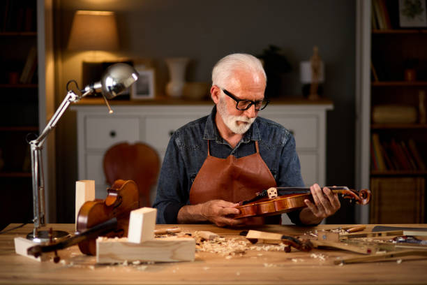 istock Senior carpenter craftsman making violin instrument 1714961731