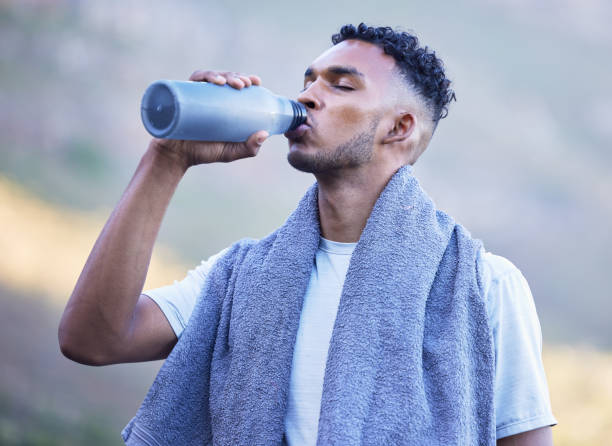 istock Fitness, exercise and a man drinking water outdoor on a break or rest after run, workout or training. Tired athlete person or runner in nature with a bottle for thirst, cardio or health and wellness 1714962882