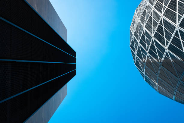 istock Tall office buildings, viewed from below, modern and rounded, with a blue background and copy space. 1714963458