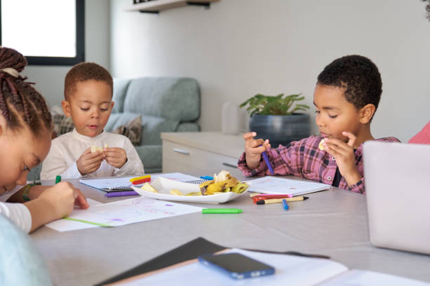 istock Three children having a snack while painting or doing the homework. 1714987777