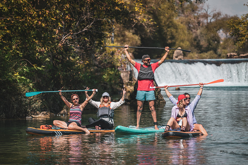 Group of Friends Posing for the Camera While Rowing (sup) on the River