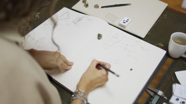 Woman designing jewelry in her atelier