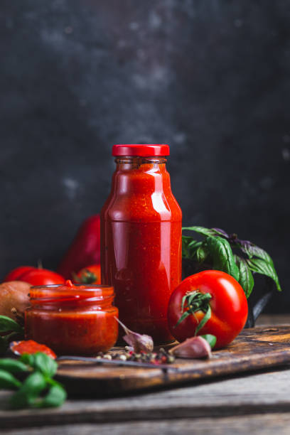 istock Ketchup in a jar. Tomato sauce on a dark background 1715004388