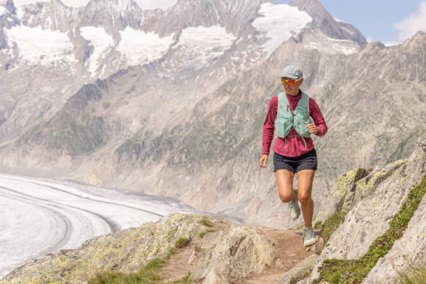 istock Female trail runner ascends alpine path in Swiss mountain landscape 1715012277