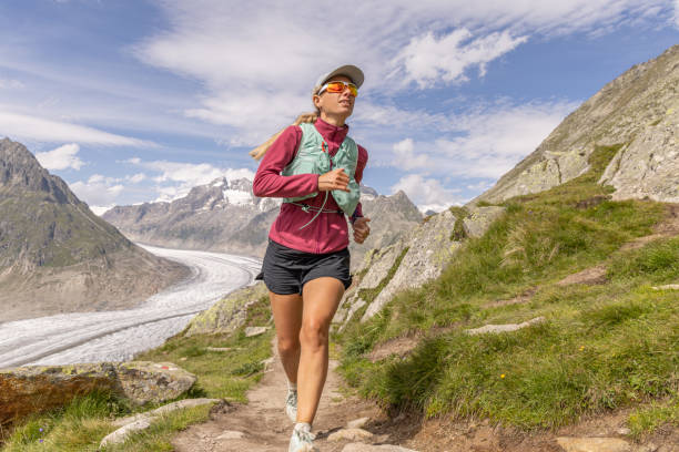 trail runner femminile sale sentiero alpino nel paesaggio montano svizzero - journey footpath exercising effort foto e immagini stock