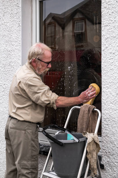 istock Senior man using a sponge to wash his window 1715023017