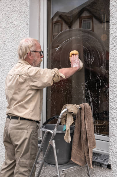 istock Retired man using a sponge to wash a window 1715024168