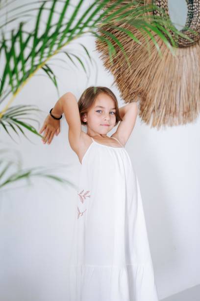 istock Girl leaning on a white wall in a summer interior 1715027039