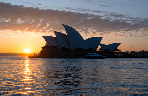 Sydney Australia - August 29, 2023: Early morning in Sydney, and the iconic Opera House and a glorious sunrise is reflected in the waters of Circular Quay.