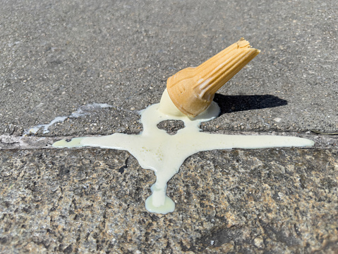 Ice cream with cone fallen on sidewalk