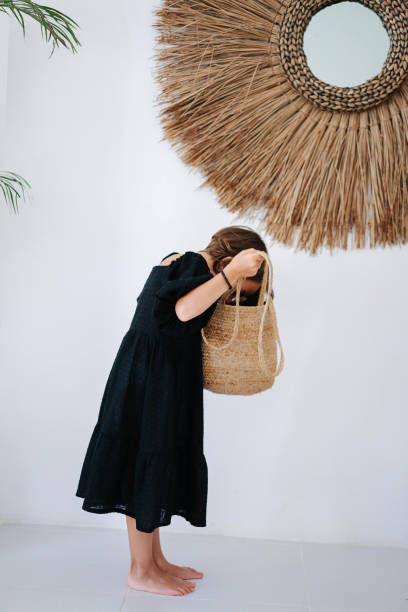 istock barefoot girl looking into a wicker bag 1715035902